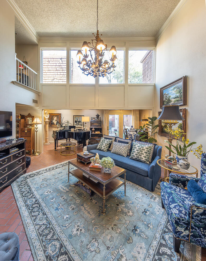 2302 Slide Road, Unit 25 Lubbock, TX 79407 - Photo 12 of 40 a living room with furniture and a chandelier