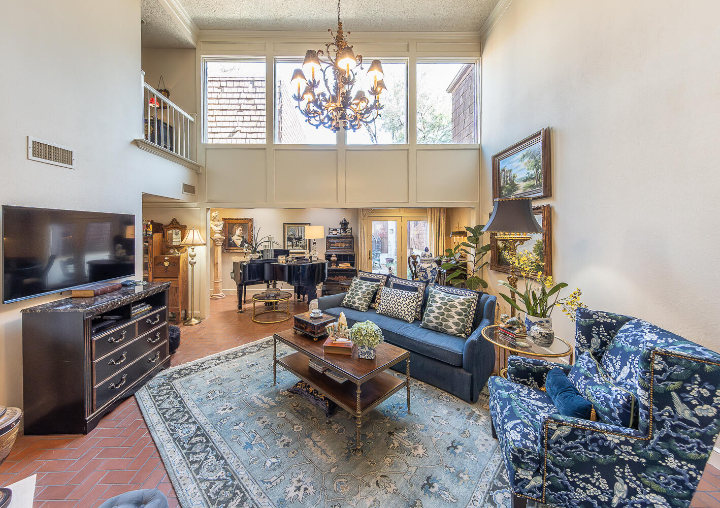 2302 Slide Road, Unit 25 Lubbock, TX 79407 - Photo 2 of 40 a living room with furniture a chandelier and a flat screen tv