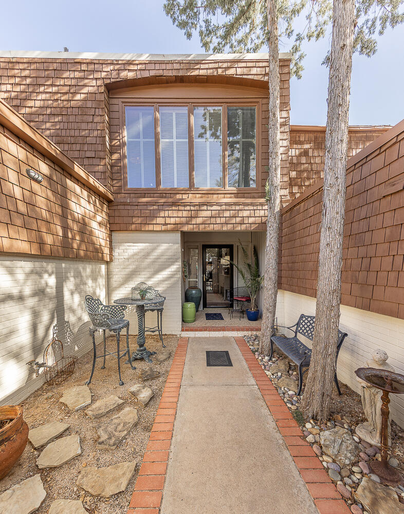2302 Slide Road, Unit 25 Lubbock, TX 79407 - Photo 28 of 40 a view of a patio with table and chairs with wooden floor and fence