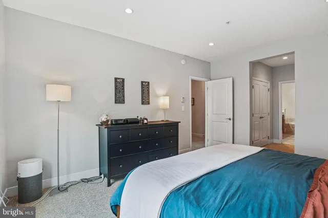 a bedroom with a bed and a lamp on dresser