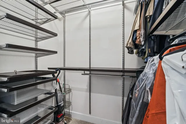 a view of walk in closet with clothes and shoes