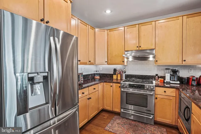 a kitchen with a stove a refrigerator and a window