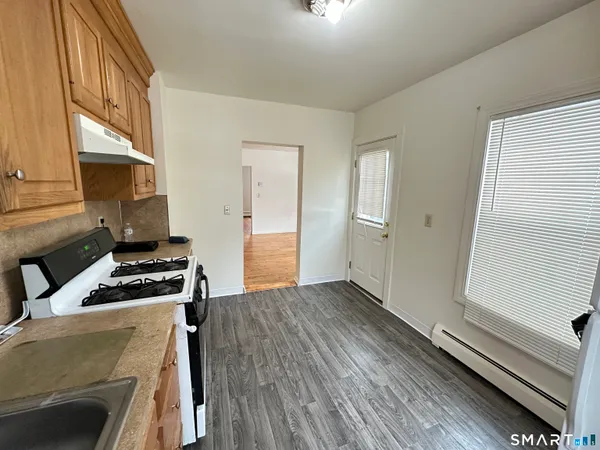 a kitchen with wooden floor and a stove top oven