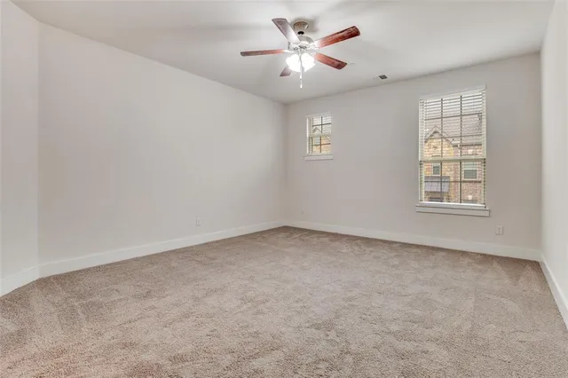 an empty room with a window and a ceiling fan