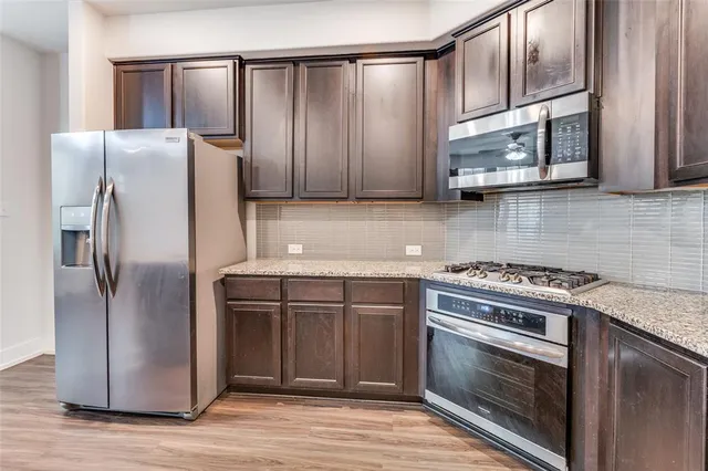 a kitchen with stainless steel appliances granite countertop a stove a refrigerator and a microwave