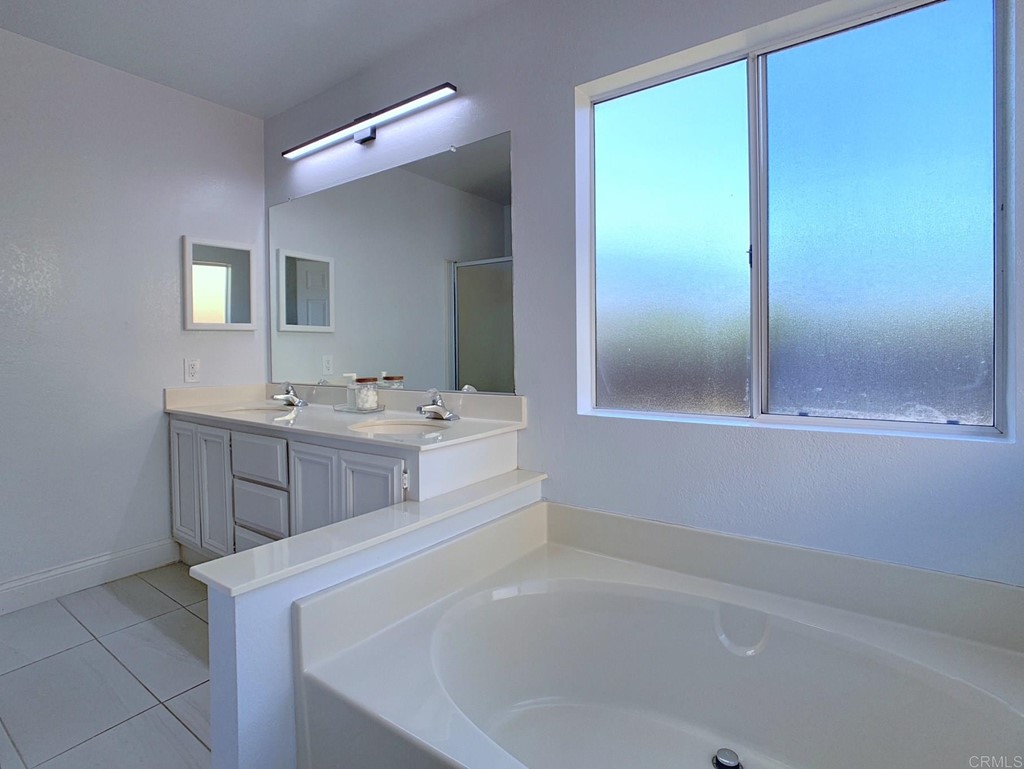 15935 Spring Oaks Road, Unit 63 El Cajon, CA 92021 - Photo 15 of 38 a bathroom with a sink a mirror and a bathtub