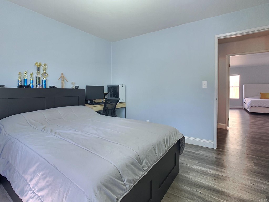 15935 Spring Oaks Road, Unit 63 El Cajon, CA 92021 - Photo 22 of 38 a bedroom with a bed and wooden floor
