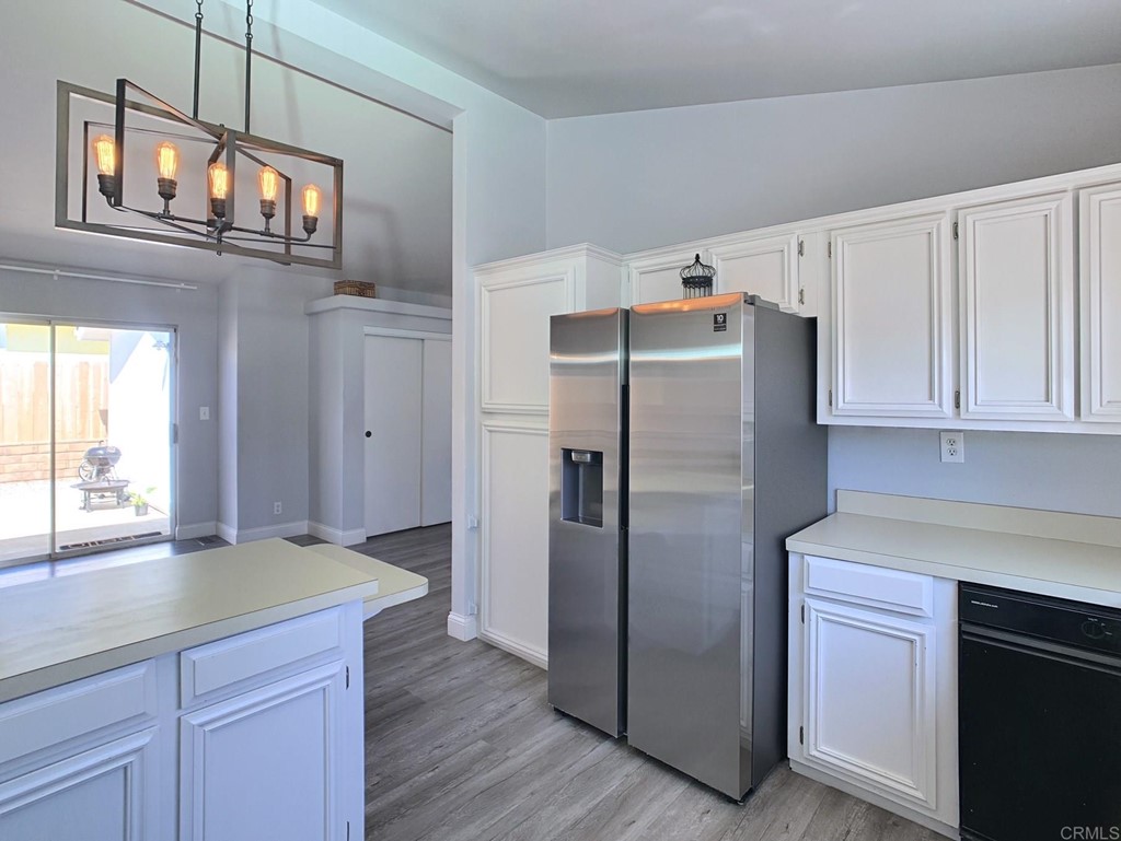 15935 Spring Oaks Road, Unit 63 El Cajon, CA 92021 - Photo 5 of 38 a kitchen with stainless steel appliances granite countertop a refrigerator a stove and a sink with cabinets