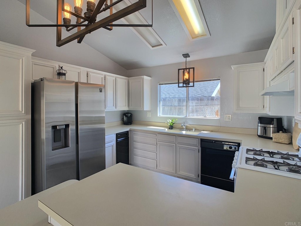15935 Spring Oaks Road, Unit 63 El Cajon, CA 92021 - Photo 7 of 38 a kitchen with stainless steel appliances granite countertop a refrigerator a sink a stove and island