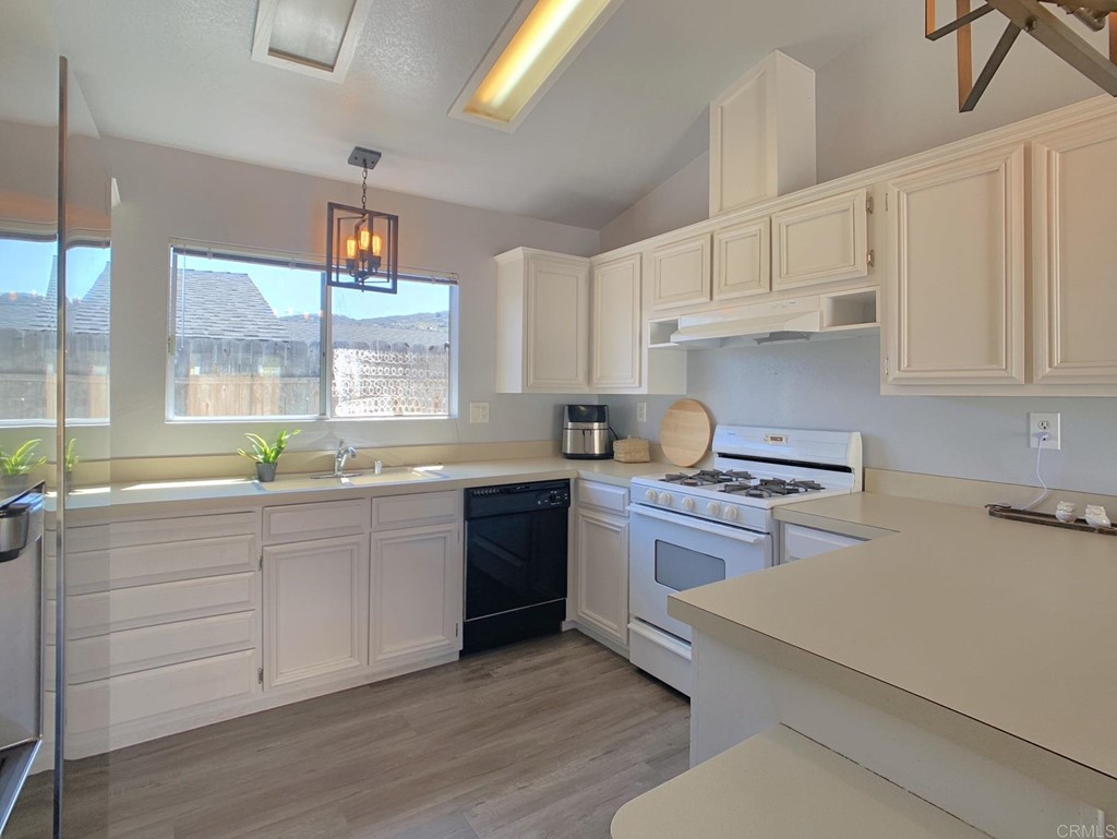 15935 Spring Oaks Road, Unit 63 El Cajon, CA 92021 - Photo 8 of 38 a kitchen with granite countertop white cabinets and white appliances