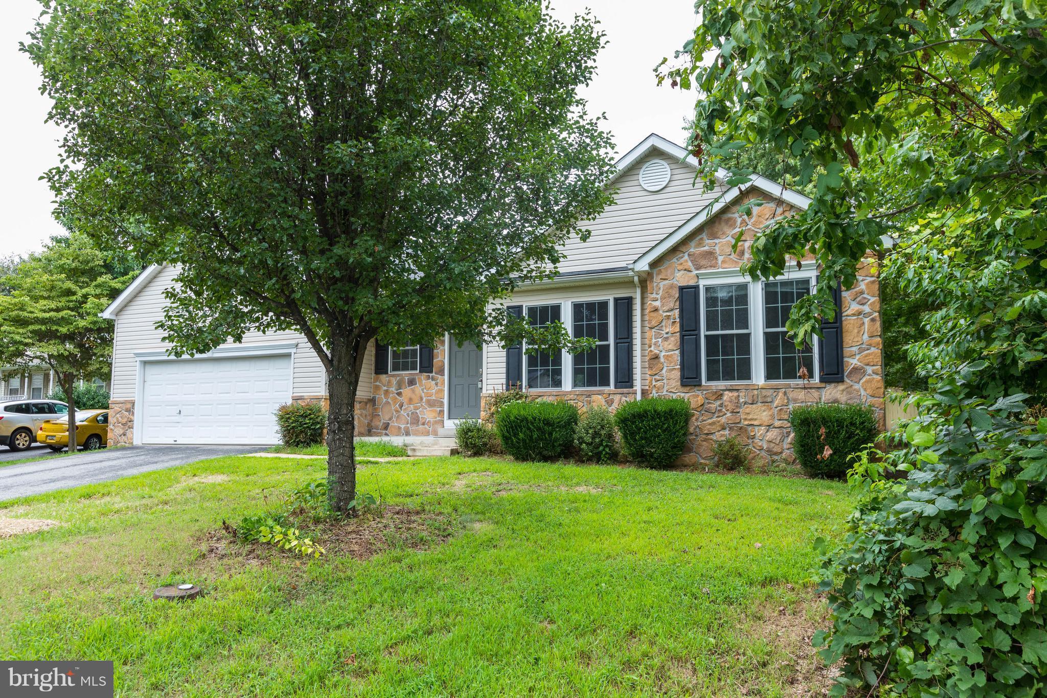 11207 Rawhide Road Lusby, MD 20657 - Photo 1 of 25 a view of a house next to a big yard and large trees