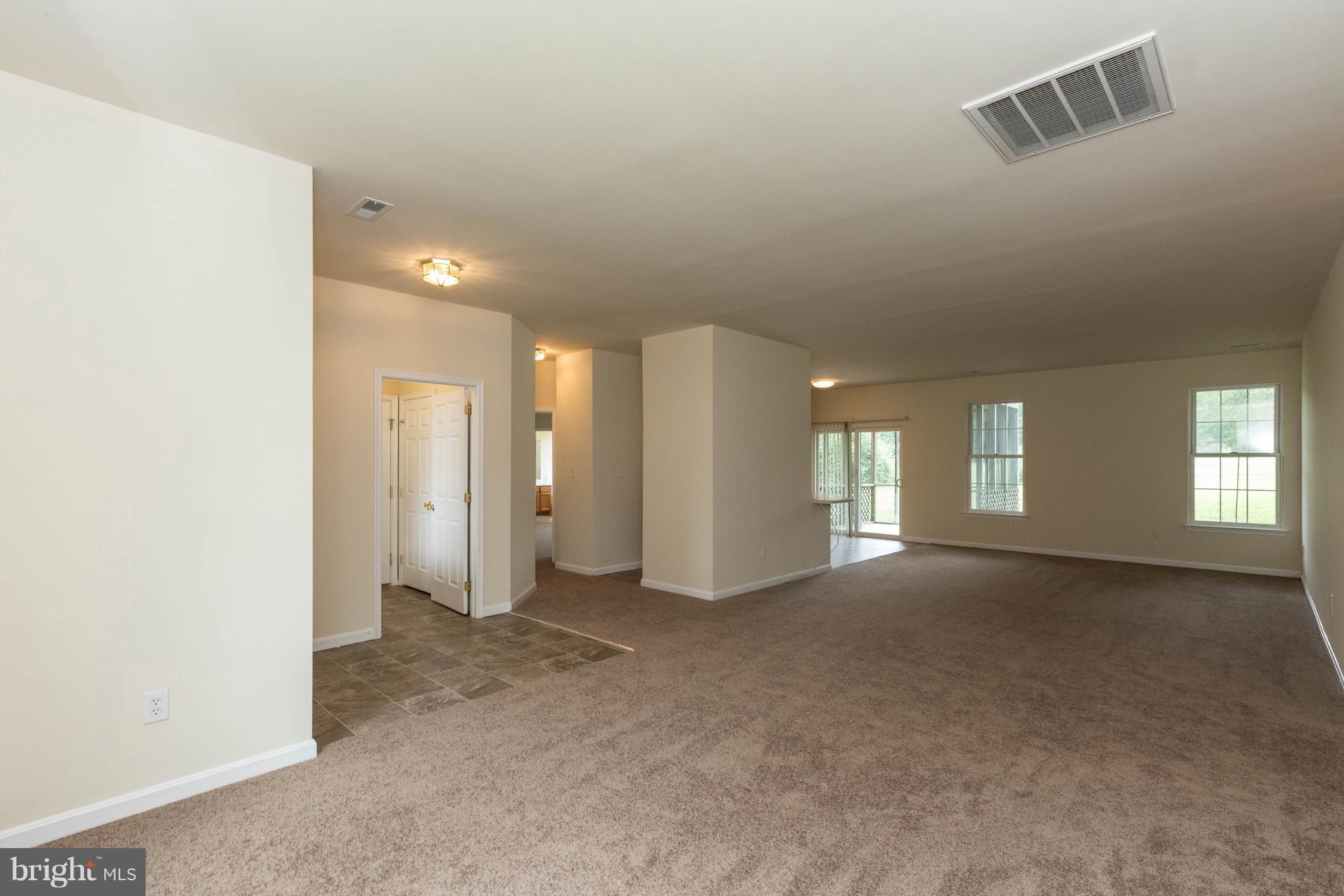 11207 Rawhide Road Lusby, MD 20657 - Photo 3 of 25 an empty room with windows and entrance