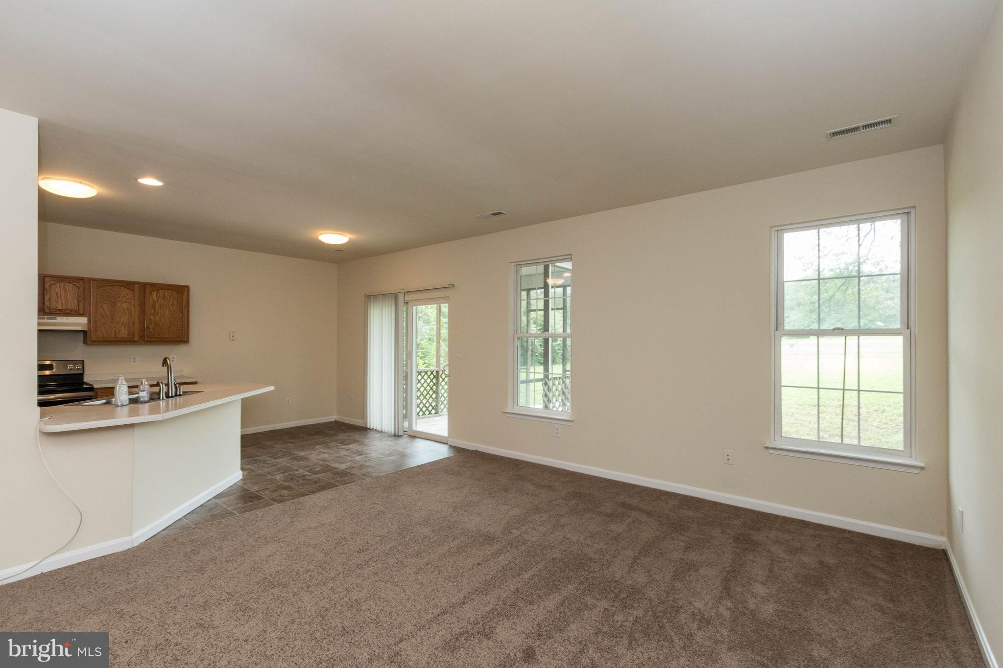 11207 Rawhide Road Lusby, MD 20657 - Photo 5 of 25 a view of a kitchen with kitchen island a sink wooden floor and a large window