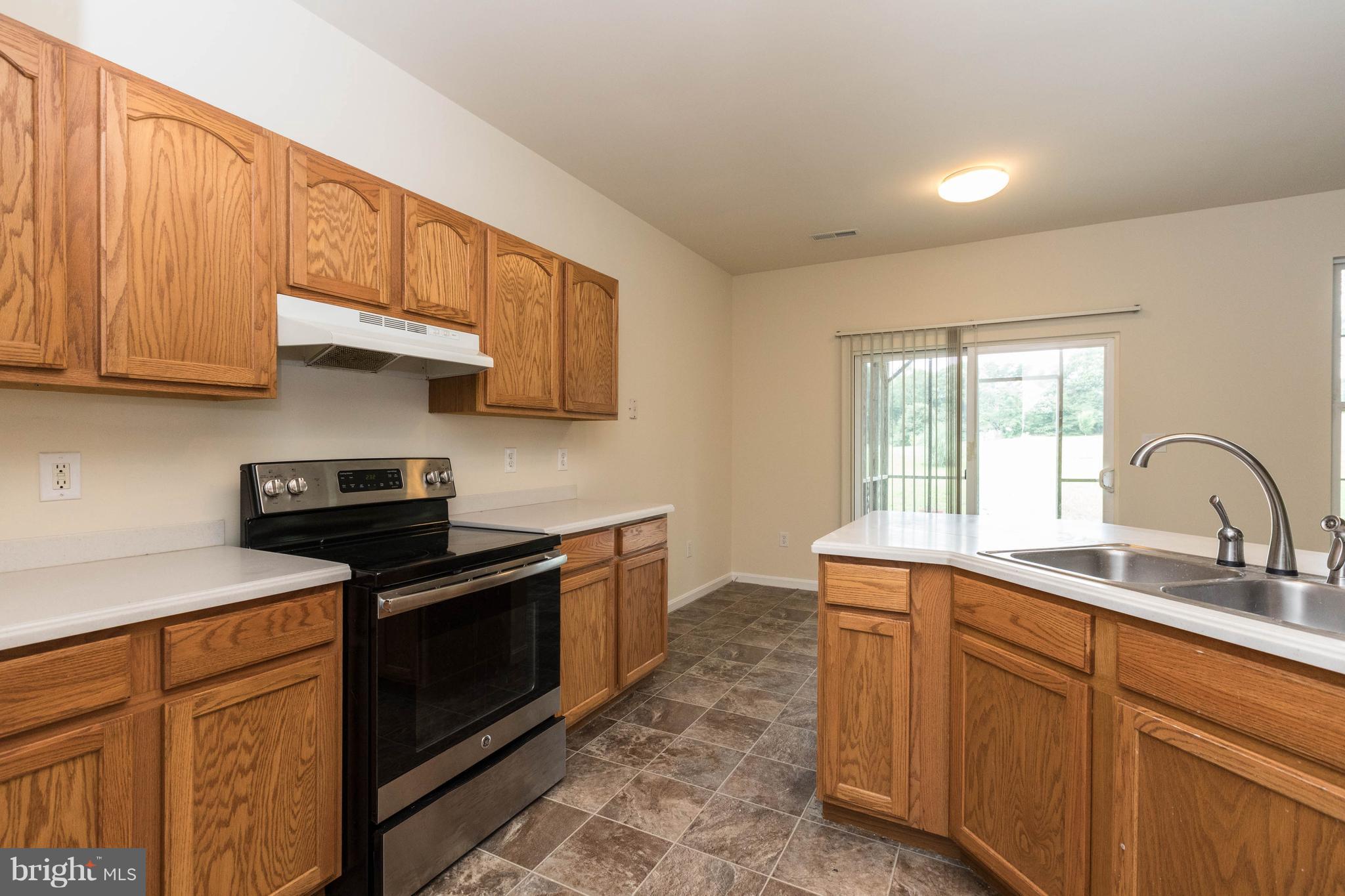 11207 Rawhide Road Lusby, MD 20657 - Photo 8 of 25 a kitchen with stainless steel appliances granite countertop a sink stove and cabinets