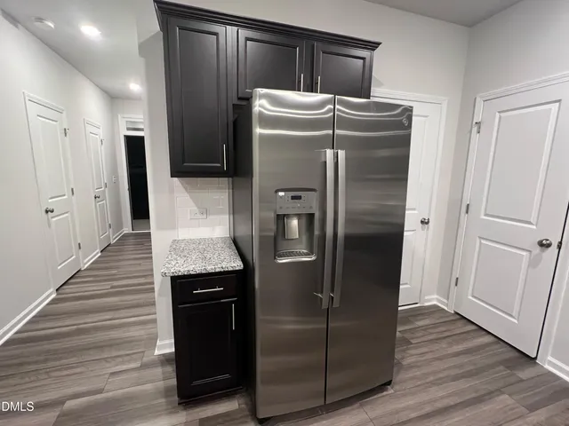 a kitchen with stainless steel appliances granite countertop a refrigerator and a sink