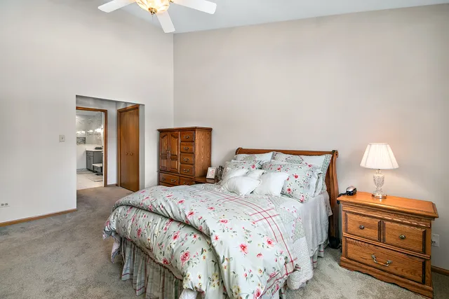 a bedroom with a bed and a lamp on dresser