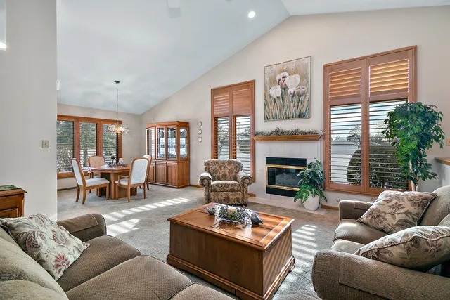 a living room with furniture fireplace and a large window