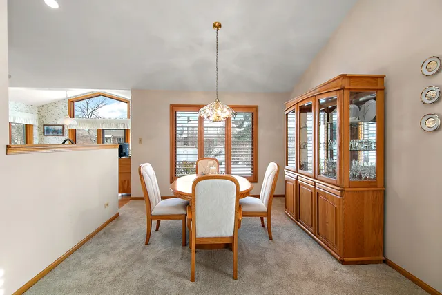 a dining room with furniture a chandelier and wooden floor
