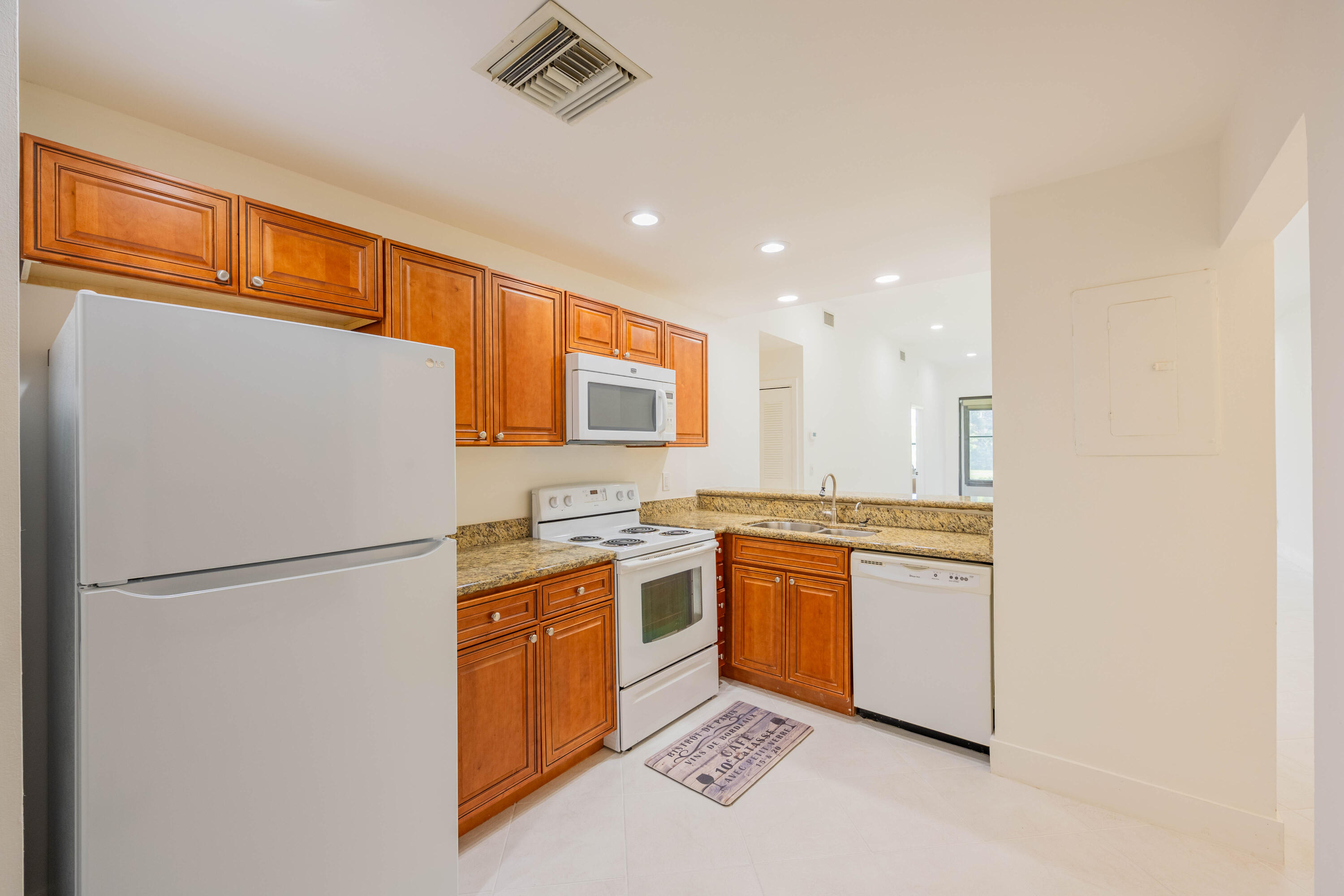 7520 La Paz Boulevard, Unit 104 Boca Raton, FL 33433 - Photo 14 of 56 a kitchen with stainless steel appliances granite countertop a refrigerator a stove a sink and a refrigerator