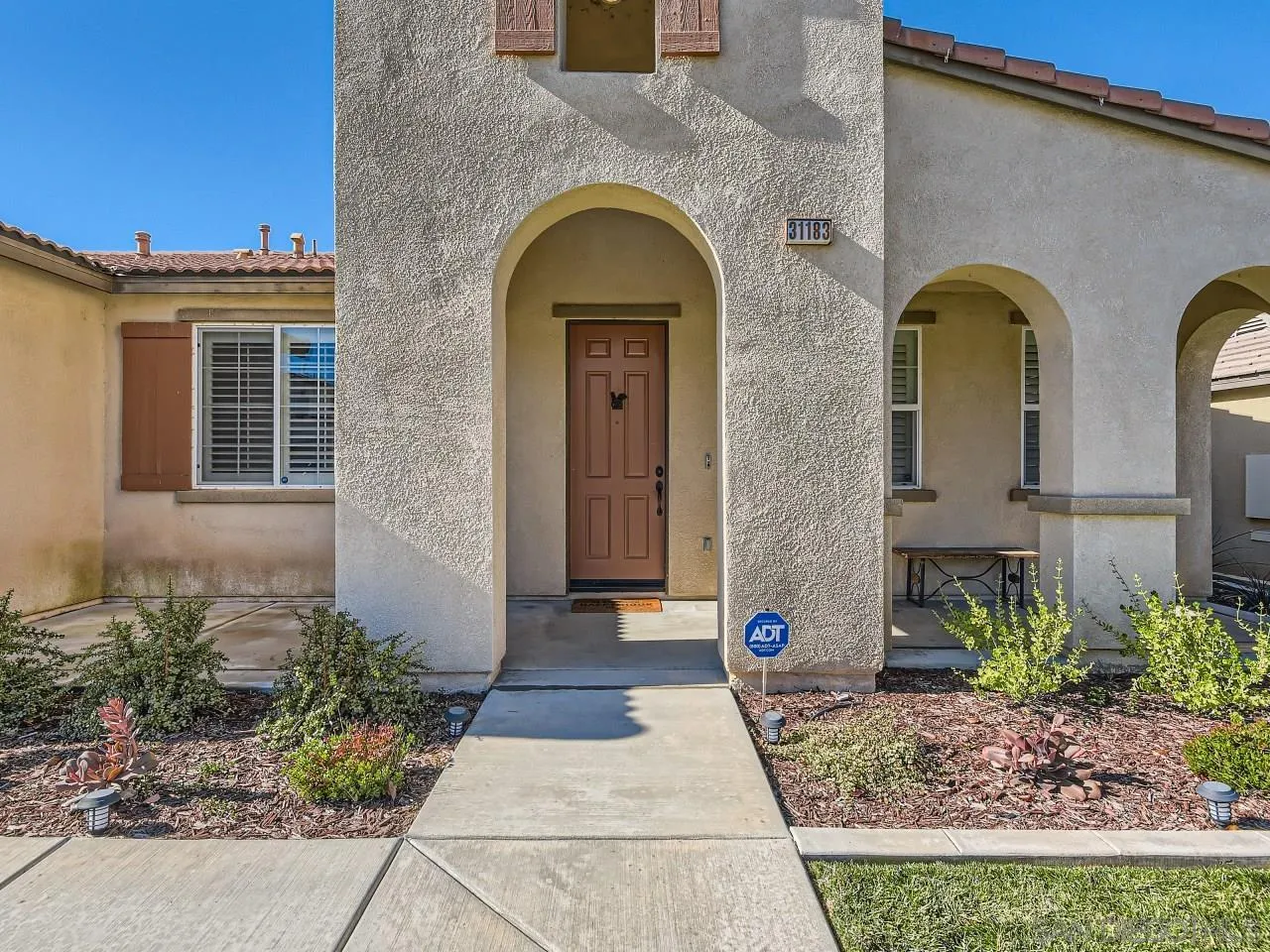 31183 Tiverton Road Menifee, CA 92584 - Photo 4 of 25 a view of a brick house with potted plants