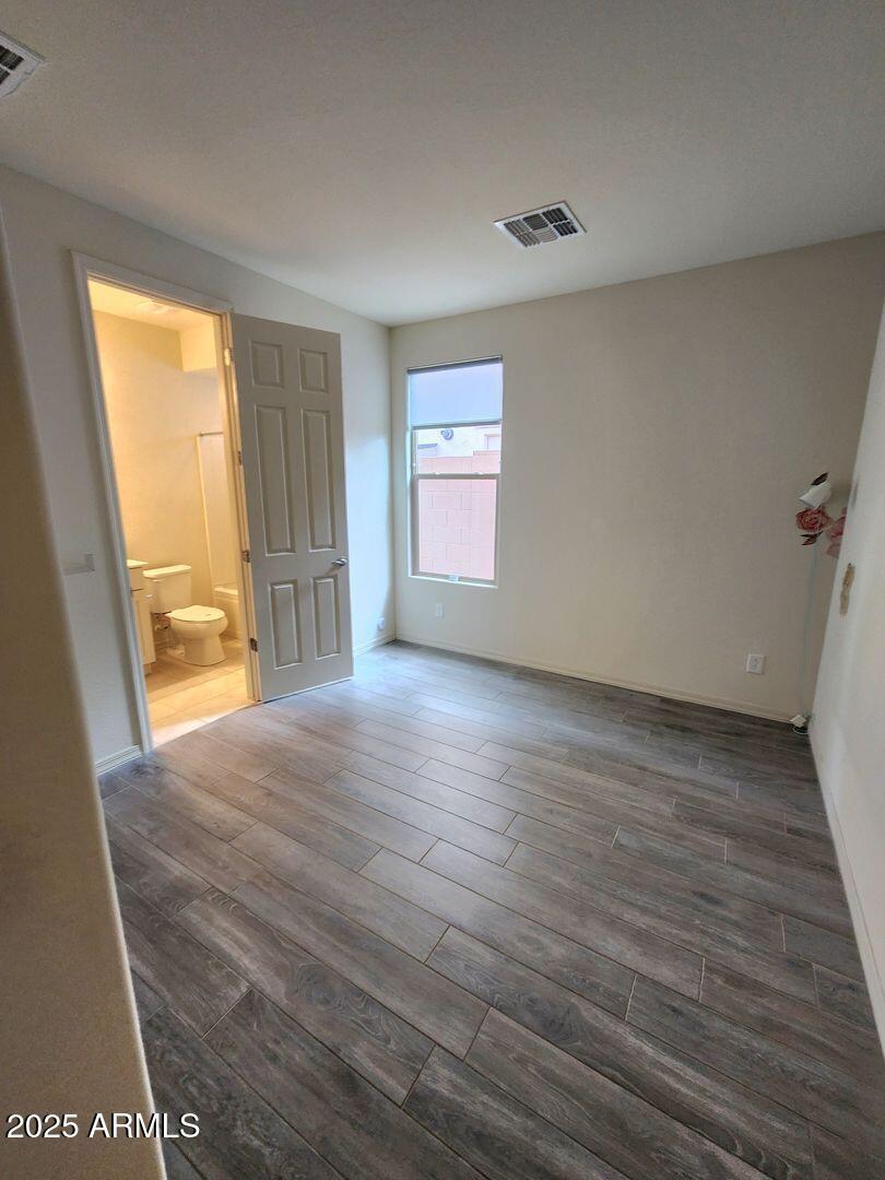 7198 West Bajada Road Peoria, AZ 85383 - Photo 13 of 36 a view of an empty room with wooden floor and a window