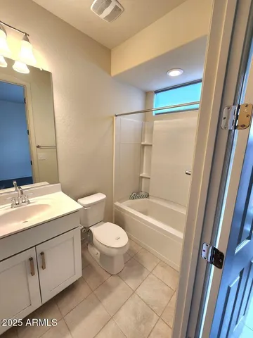 a bathroom with a granite countertop sink toilet mirror vanity and bathtub