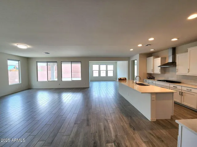 a living room with stainless steel appliances granite countertop wooden floors and view living room