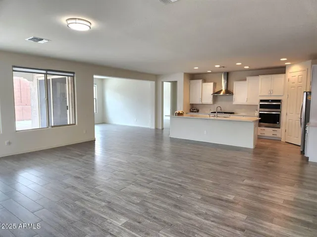 an open kitchen with white cabinets and wooden floor