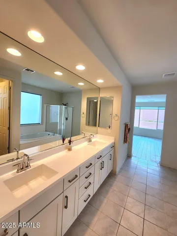 a spacious bathroom with a granite countertop sink and a large mirror