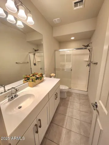 a bathroom with a double vanity sink mirror and shower