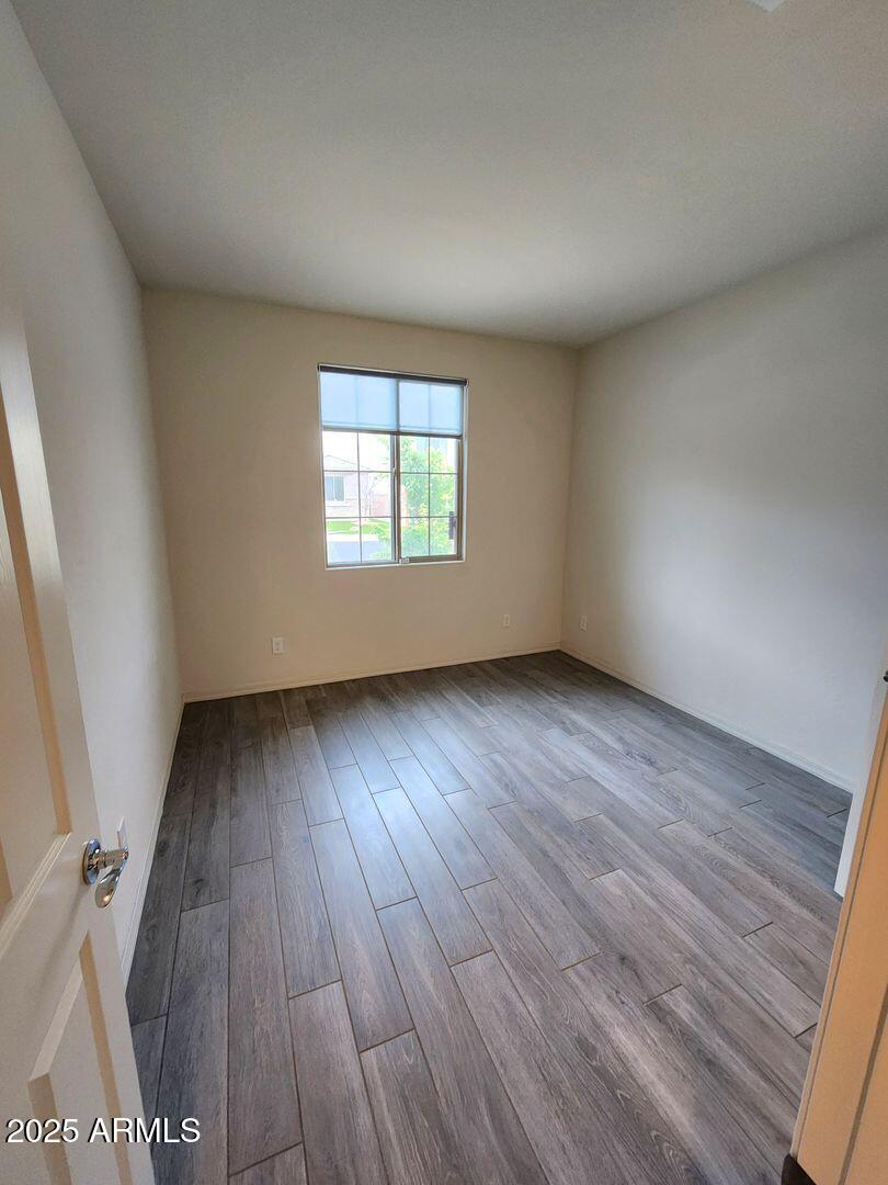 7198 West Bajada Road Peoria, AZ 85383 - Photo 8 of 36 an empty room with wooden floor and windows