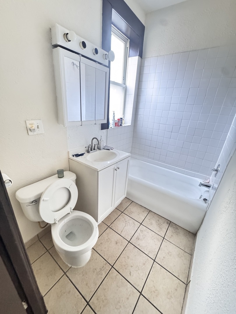 4459 West Jackson Boulevard Chicago, IL 60624 - Photo 11 of 14 a bathroom with a sink a toilet and tub