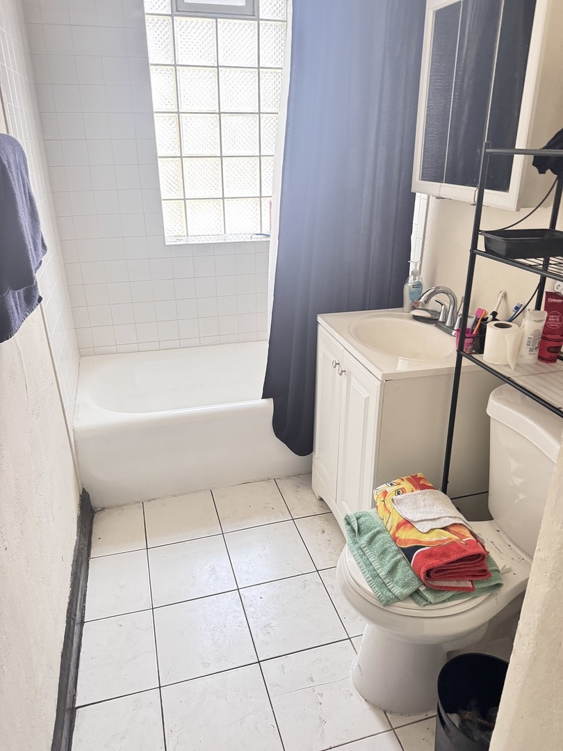 4459 West Jackson Boulevard Chicago, IL 60624 - Photo 4 of 14 a bathroom with a sink toilet and window