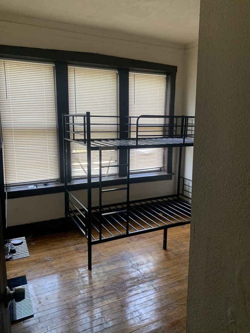 4459 West Jackson Boulevard Chicago, IL 60624 - Photo 8 of 14 a bedroom with wooden floor and a window