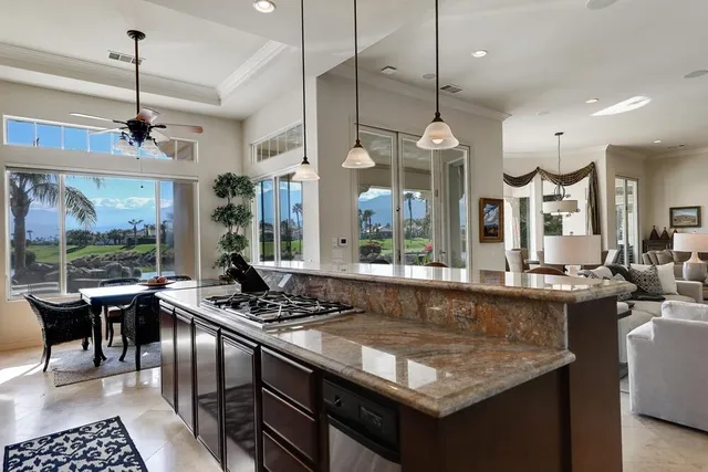 a kitchen with kitchen island granite countertop a stove and a sink