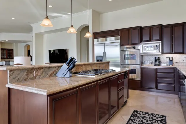a kitchen with a table chairs refrigerator and microwave