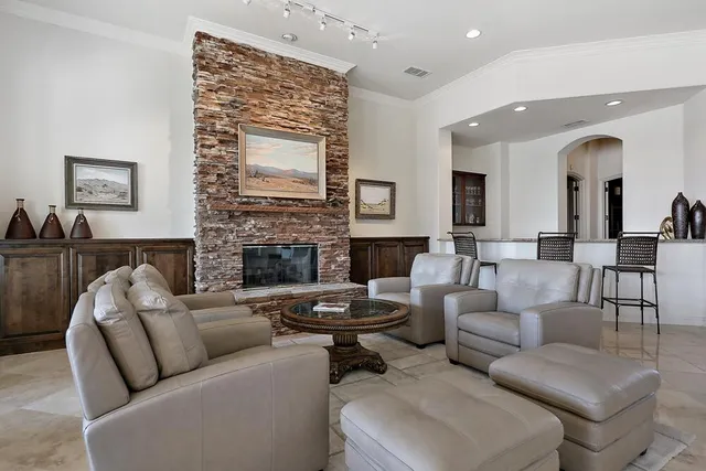 a living room with furniture a large window and a fireplace