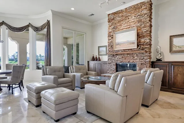 a living room with furniture kitchen view and a wooden floor