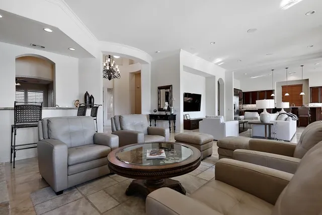 a living room with furniture kitchen view and a chandelier