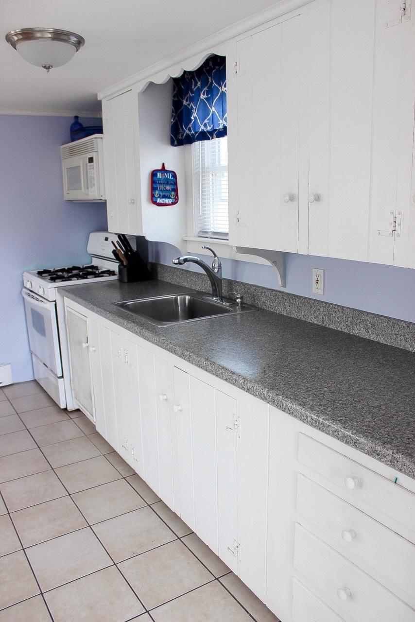 4 Beach Road West Dennis, MA 02670 - Photo 7 of 22 a kitchen with stainless steel appliances a sink dishwasher and white cabinets