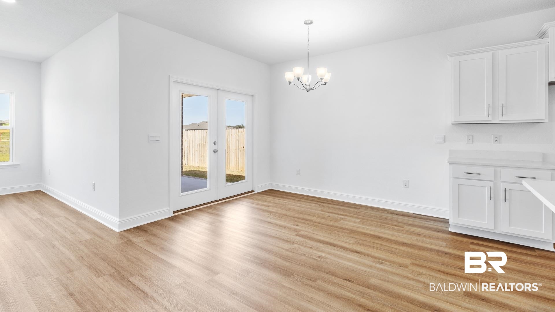 12931 Grand Rpds Road Fairhope, AL 36532 - Photo 16 of 33 Unfurnished dining area featuring a healthy amount of sunlight, light wood-type flooring, and baseboards