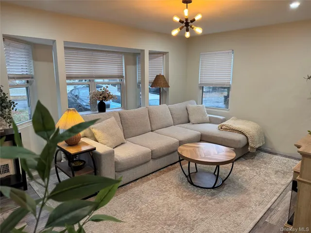 a living room with furniture a chandelier and a couch