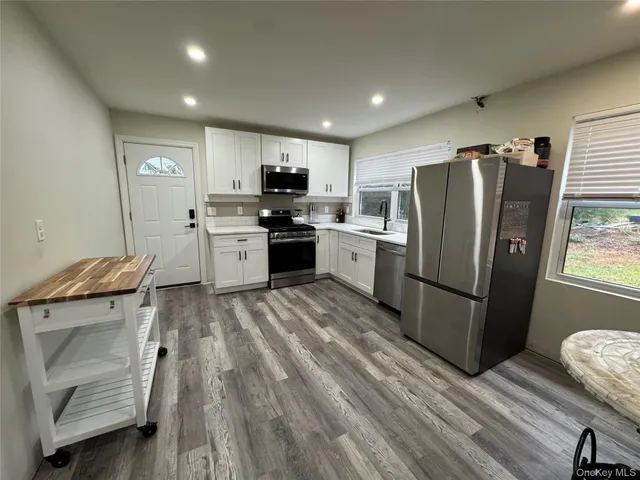 a kitchen with stainless steel appliances granite countertop a refrigerator stove and sink