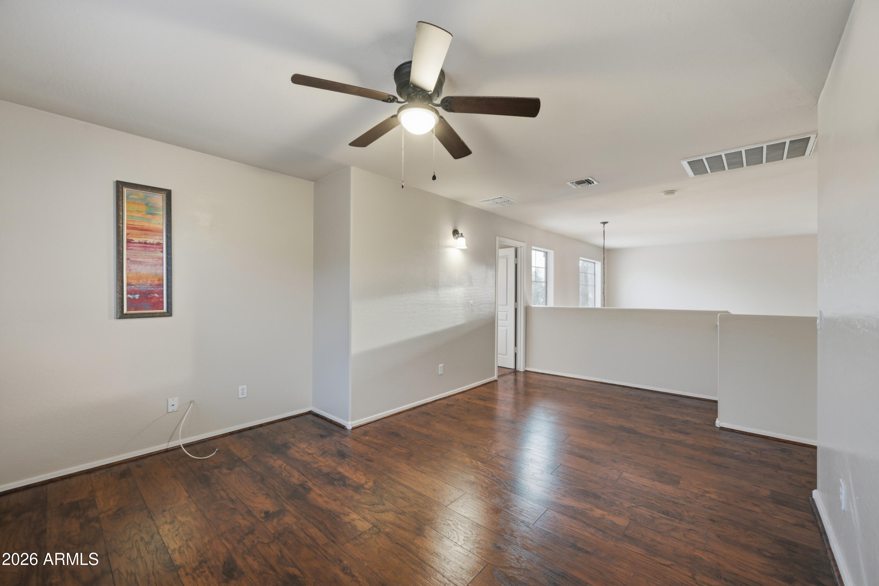 4372 West Alta Vista Road Laveen, AZ 85339 - Photo 27 of 47 a view of an empty room with wooden floor and a ceiling fan