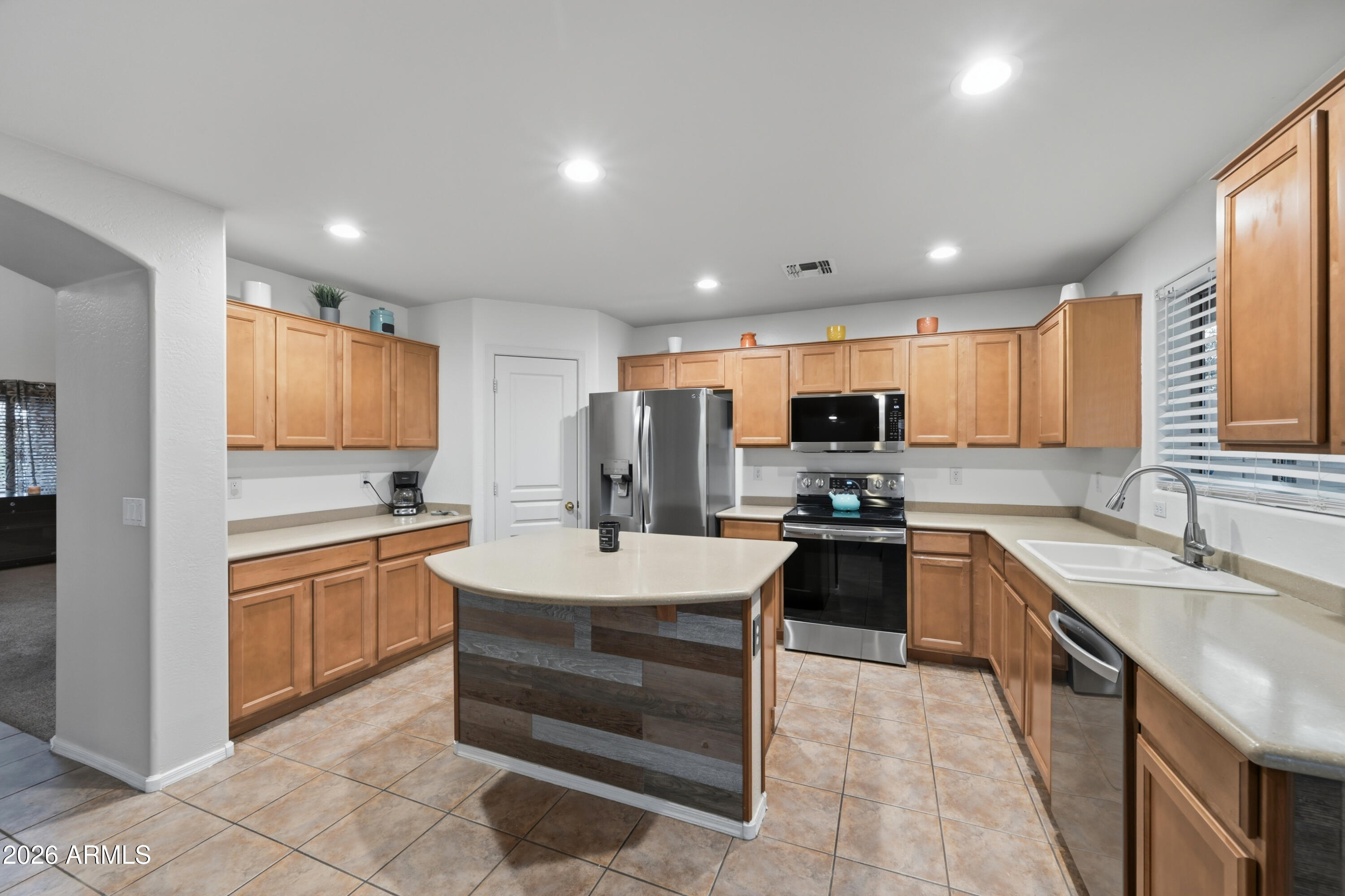 4372 West Alta Vista Road Laveen, AZ 85339 - Photo 38 of 47 a large kitchen with stainless steel appliances kitchen island granite countertop a sink and dishwasher a stove with wooden cabinets