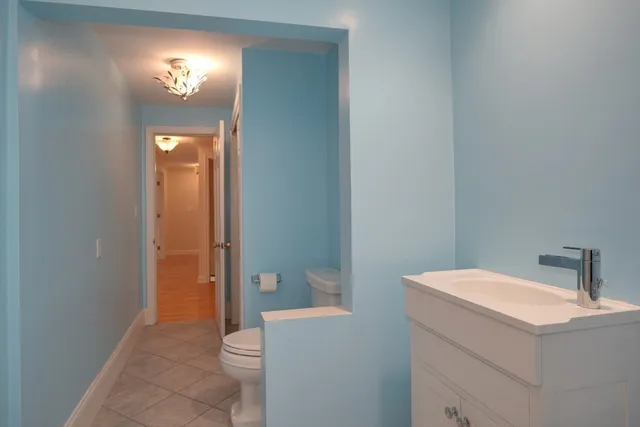a bathroom with a toilet sink and mirror