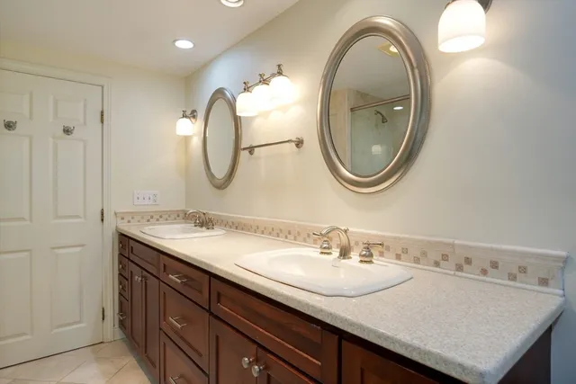 a bathroom with a granite countertop double vanity sinks and a mirror