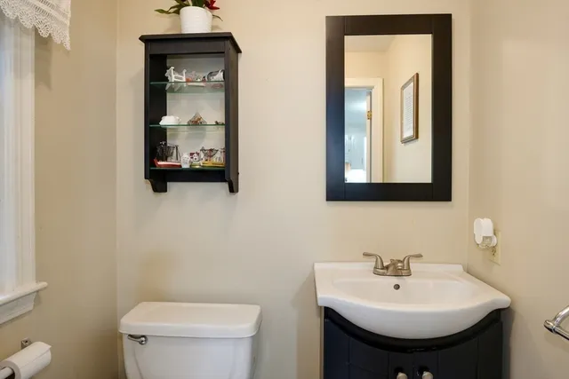 a bathroom with a toilet sink and mirror