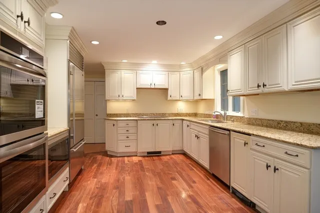 a kitchen with a sink window and stainless steel appliances