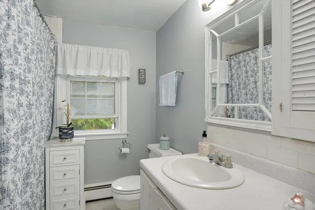 a bathroom with a sink toilet a mirror and shower